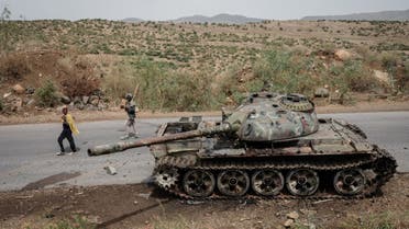  In this file photo taken on June 20, 2021 Local farmers walk next to a tank of alledged Eritrean army that is abandoned along the road in Dansa, southwest of Mekele in Tigray region, Ethiopia. (AFP)