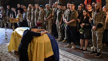 Nadiya, the mother of late Ukrainian serviceman Roman Barvinok, mourns at his coffin during a funeral service in St. Michael's Golden-Domed Cathedral in Kyiv on August 28, 2022, amid the Russian invasion of Ukraine. (AFP)