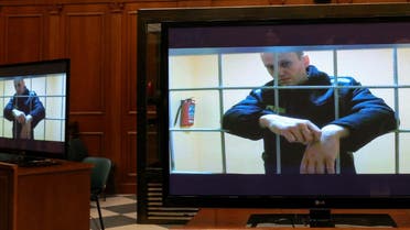 Russian opposition leader Alexei Navalny is seen on screens via a video link from the IK-2 corrective penal colony in Pokrov during a court hearing to consider an appeal against his prison sentence in Moscow, Russia May 24, 2022. (AFP)