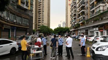 Police officers speak to people behind a police line near a residential area where only entering is allowed, following new cases of the coronavirus disease (COVID-19), in Guangzhou's Liwan district, Guangdong province, China May 29, 2021. (File photo: Reuters)