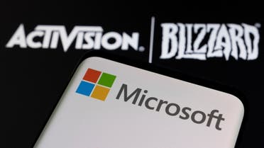Microsoft logo is seen on a smartphone placed on displayed Activision Blizzard logo in this illustration taken January 18, 2022. (Reuters)