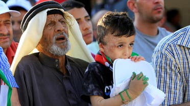 Palestinian boy Ahmed Dawabsha, who suffered severe burns in an arson attack by Jewish attackers on his family home in 2015 in which his younger brother, Ali, and his parents both died, is carried by his grandfather during an event marking the first anniversary of the incident in the West Bank village of Duma near Nablus July 31, 2016. (File photo: Reuters)