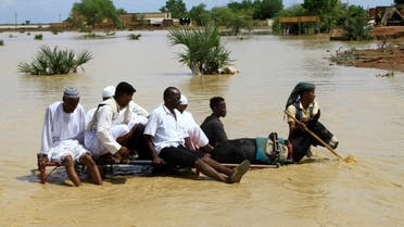 Sudanese cross a flooded road in the town of Iboud, in al-Gezira state, 250kms south of the capital Khartoum, on August 22, 2022. (AFP)