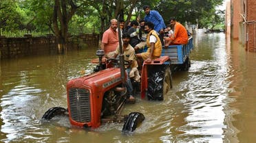 Residents are evacuated to safer places in a tractor trolley after heavy rains caused flooding in a residential area in Bengaluru, India, November 22, 2021. (Reuters) 