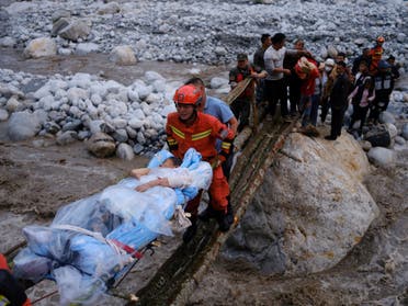 عمال الإنقاذ يحملون أحد المصابين في أعقاب الزلزال الذي ضرب لودينغ في سيتشوان الاثنين (رويترز)