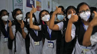 Girls gesture after receiving a dose of Bharat Biotech's COVID-19 vaccine, Covaxin, during a vaccination drive for children aged 15-18 in Mumbai, India, on January 3, 2022. (Reuters)