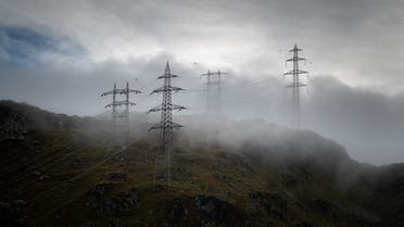 A photograph shows electricity pylons on a misty morning near Nufenenpass above Ulrichen, Switzerland, September 2, 2022. (AFP)