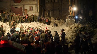 Syrian army soldiers look on as rescuers search for victims and survivors amidst the rubble of a building that collapsed in Syria's northern city of Aleppo, on September 7, 2022. (AFP)
