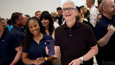 Apple CEO Tim Cook reacts as he holds the new iPhone 14 at an Apple event at their headquarters in Cupertino, California, US, on September 7, 2022. (Reuters)