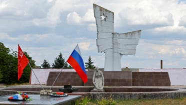 A view shows a Russian and Soviet-era flags at a World War Two memorial during Ukraine-Russia conflict in the Russia-controlled village of Chornobaivka, Ukraine July 26, 2022. (Reuters)