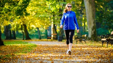 Mid aged woman running in city park stock photo