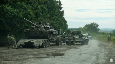 This handout photograph taken on September 9, 2022 and released by the press-service of the Commander-in-Chief of the Ukrainian Armed Forces on September 11, 2022, shows Ukrainian soldiers loading an abandoned Russian military vehicule on a trailer during the Ukarinian Army counter-offensive in Kharkiv region, amid the Russian military invasion of Ukraine. (AFP) 