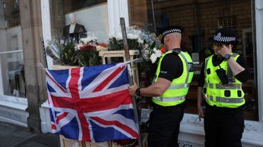 Police officers move flowers following the death of Britain's Queen Elizabeth, at the Royal Mile, in Edinburgh, Scotland, Britain September 12, 2022. (Reuters)