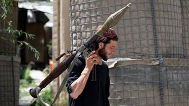 In this photograph taken on July 8, 2022, a Taliban fighter carries a rocket-propelled grenade (RPG) at a road checkpoint near the Bazarak district in Panjshir Province. 