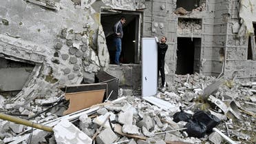 Local residents stand outside their building partially destroyed by a missile strike on Kharkiv on September 12, 2022 amid the Russian invasion of Ukraine. (AFP)