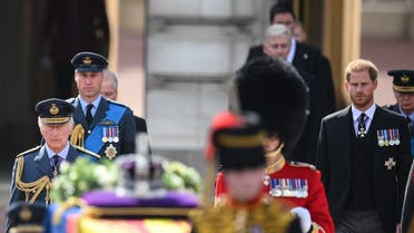 Britain's King Charles III (L), Britain’s Prince William, Prince of Wales (2L) and Britain’s Prince Harry, Duke of Sussex walk behind the coffin of Queen Elizabeth II, adorned with a Royal Standard and the Imperial State Crown and pulled by a Gun Carriage of The King’s Troop Royal Horse Artillery, during a procession from Buckingham Palace to the Palace of Westminster, in London on September 14, 2022. (AFP)