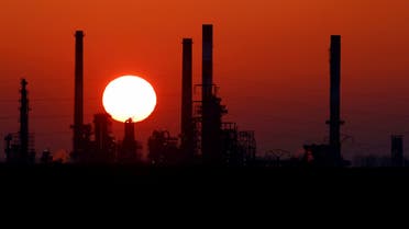 The sun sets behind the chimneys of the Total Grandpuits oil refinery, southeast of Paris, France. (Reuters)