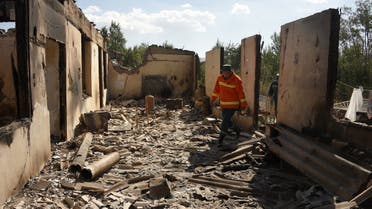 Firefighters work among the ruins of a house, which is said was hit by Azeri shelling during recent border clashes with Azerbaijan, in the settlement of Sotk, Armenia, on September 14, 2022. (AFP)