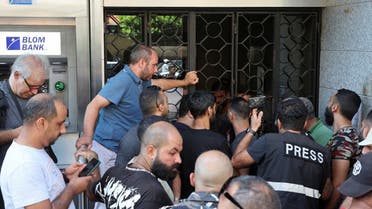 People stand outside a Blom Bank branch in the Tariq al-Jdideh neighborhood in Beirut, Lebanon, on September 16, 2022. (Reuters)