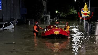 Rescue workers arrive on a dinghy boat on a flooded street after heavy rains hit the east coast of Marche region in Senigallia, Italy, September 16, 2022. (Reuters)