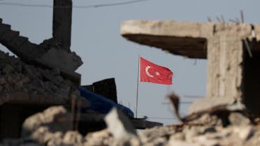 Turkish flag flutters at Turkey's border gate, as pictured on Syria side, overlooking the ruins of buildings destroyed during fightings with the Islamic State militants in Kobani, Syria October 11, 2017. Picture taken October 11, 2017. REUTERS/Erik De Castro
