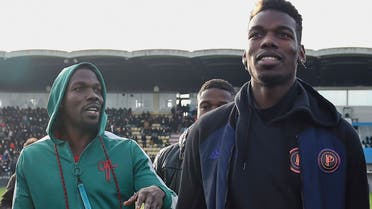 This file photo taken on December 29, 2019 shows France national team player Paul Pogba (R) and his brother Mathias Pogba (L) walking on the pitch prior to a football match between All Star France and Guinea at the Vallee du Cher Stadium in Tours, central France, as part of the 48h for Guinea charity event. (AFP)