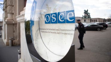 A police officer is reflected in the logo of the OSCE (Organization for Security and Cooperation in Europe) at the OSCE headquarters in the Hofburg Palace in Vienna February 21, 2022. (AFP)