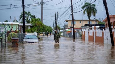 A member of the Puerto Rico National Guard wades through water in search for people to be rescued from flooded streets in the aftermath of Hurricane Fiona in Salinas, Puerto Rico September 19, 2022. (Reuters)