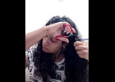 A woman near Bologna, Italy, cuts her hair off with scissors in protest following the death of jailed Iranian woman, Mahsa Amini, for wearing an improper hijab. (Reuters)