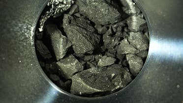 This handout photograph released by the Japan Aerospace Exploration Agency (JAXA) on December 24, 2020 shows samples of soil from the asteroid Ryugu, inside C compartment of the capsule collected by the Hayabusa-2 space probe, at JAXA Sagamihara Campus in Sagamihara, Kanagawa prefecture. (Handout/JAXA/AFP)
