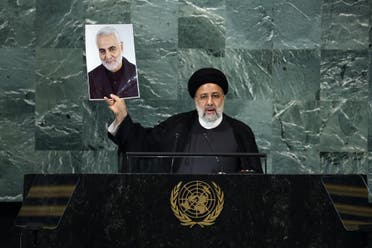 Iranian President Ebrahim Raisi holds a photo of Quds Force commander General Qassem Soleimani, who was killed in a US attack, during his speech at the 77th session of the United Nations General Assembly (UNGA) at the UN headquarters September 21, 2022 in New York City.  (Reuters)