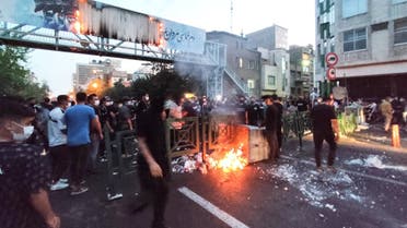 A picture obtained by AFP outside Iran on September 21, 2022, shows Iranian demonstrators burning a rubbish bin in the capital Tehran during a protest for Mahsa Amini, days after she died in police custody. (AFP)