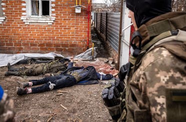  A Ukrainian soldier walks past the bodies of Russian soldiers laying on the ground after the Ukranian troops retook the village of Mala Rogan, east of Kharkiv, on March 30, 2022. Ukrainian forces on March 28, 2022 recaptured a small village on the outskirts of Ukraine's second-largest city Kharkiv, as Kyiv's forces mount counterattacks against a stalling Russian invasion. Members of the Ukrainian army were clearing and securing destroyed homes in the settlement of Mala Rogan, about five kilometres (three miles) from Kharkiv, after pushing out Russian forces.