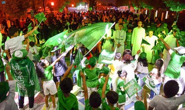 Children and adults wave flags. (SPA)