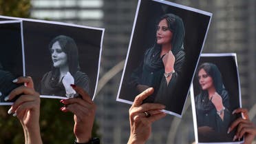 Women hold up signs depicting the image of 22-year-old Mahsa Amini, who died while in the custody of Iranian authorities, during a demonstration denouncing her death by Iraqi and Iranian Kurds outside the UN offices in Arbil, the capital of Iraq's autonomous Kurdistan region, on September 24, 2022. (AFP)