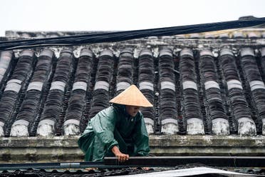 A resident consolidates the roof of house before typhoon Noru slams Vietnam, in Hoi An, Quang Nam province, on September 27, 2022. (AFP)