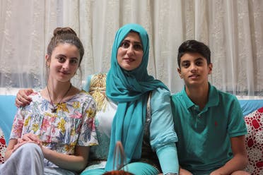 Public school teacher Claude Koteich poses for a picture with her son and daughter at their house in Deir Qubel, Lebanon September 19, 2022. (Reuters)