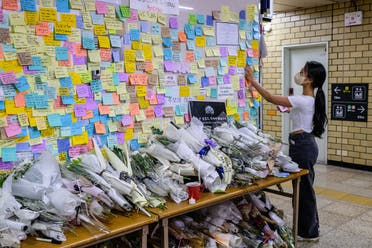 A woman pays her respects as she displays a handwritten note near the entrance to a female lavatory at Sindang Station in Seoul on September 19, 2022. (AFP)