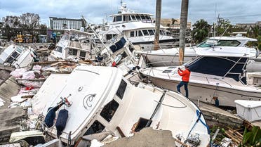 A man takes photos of boats damaged by Hurricane Ian in Fort Myers, Florida, on September 29, 2022. (AFP)