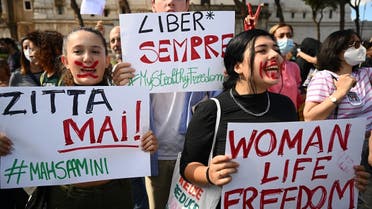People stage a protest on October 1, 2022 in Rome, following the death of Kurdish woman Mahsa Amini in Iran. The placards read “Never shut up” (L) and “Always free.” (AFP)