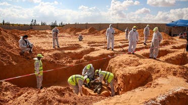 Members of the public body leading the “Search and Identification of the Missing,” unearth a body at a mass grave site in western Libya’s Tarhuna region on November 7, 2020. (AFP)