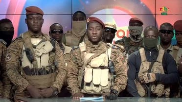 This video grab taken from a video broadcasted on October 2, 2022 by the national television of Burkina Faso shows Captain Kiswendsida Farouk Azaria Sorgho (C), member of the junta reading a statement next to Coup leader Ibrahim Traoré (L) and surrounded by members of the military who are claiming to take power on September 30, 2022 in Ouagadougou. (Radiodiffusion Télévision du Burkina/AFP)
