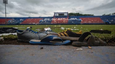 TOPSHOT - Discarded shoes sit by the pitch at Kanjuruhan stadium days after a deadly stampede following a football match in Malang, East Java on October 3, 2022. Anger against police mounted in Indonesia on October 3 after at least 125 people were killed in one of the deadliest disasters in the history of football, when officers fired tear gas in a packed stadium, triggering a stampede. (Photo by Juni Kriswanto / AFP)