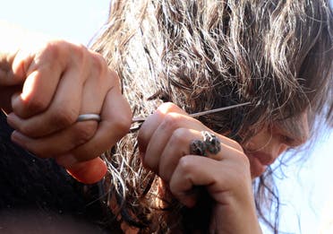 A protester cuts her hair in solidarity with Mahsa Amini - Archive from Reuters