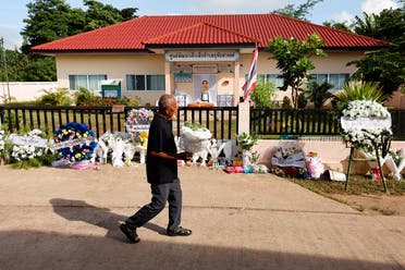 A man brings flowers in front of the day care center which was the scene of a mass shooting in the town of Uthai Sawan, in the province of Nong Bua Lam Phu, Thailand, on October 9, 2022. (Reuters)