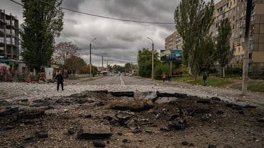 A policeman walks next to a crater following a missile strike in Dnipro on October 10, 2022, amid Russia's invasion of Ukraine. (AFP)