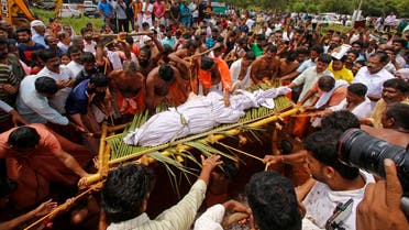 People carry the dead body of Babia, a crocodile at Ananthapura lake temple, for its burial at the Ananthapadmanabha Swamy temple at Kasaragod in India's Kerala state on October 10, 2022. (AFP)