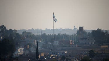 A Syrian opposition flag flutters in the Syrian town of Tal Abyad, as seen from the Turkish border town of Akcakale, in Sanliurfa province, Turkey. (Reuters)