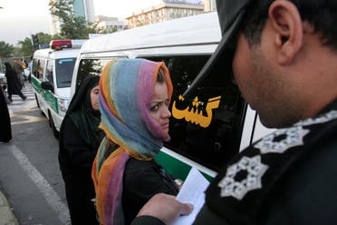 عنصر من الشرطة الينية يعتقل امرأة في إيران (رويترز)