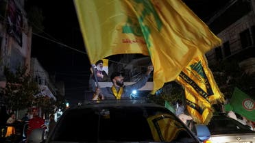 Supporters of Lebanon's Hezbollah leader Sayyed Hassan Nasrallah carry flags while riding in a convoy as votes are being counted in Lebanon's parliamentary election, in Nabatiyeh, southern Lebanon May 15, 2022. (Reuters)